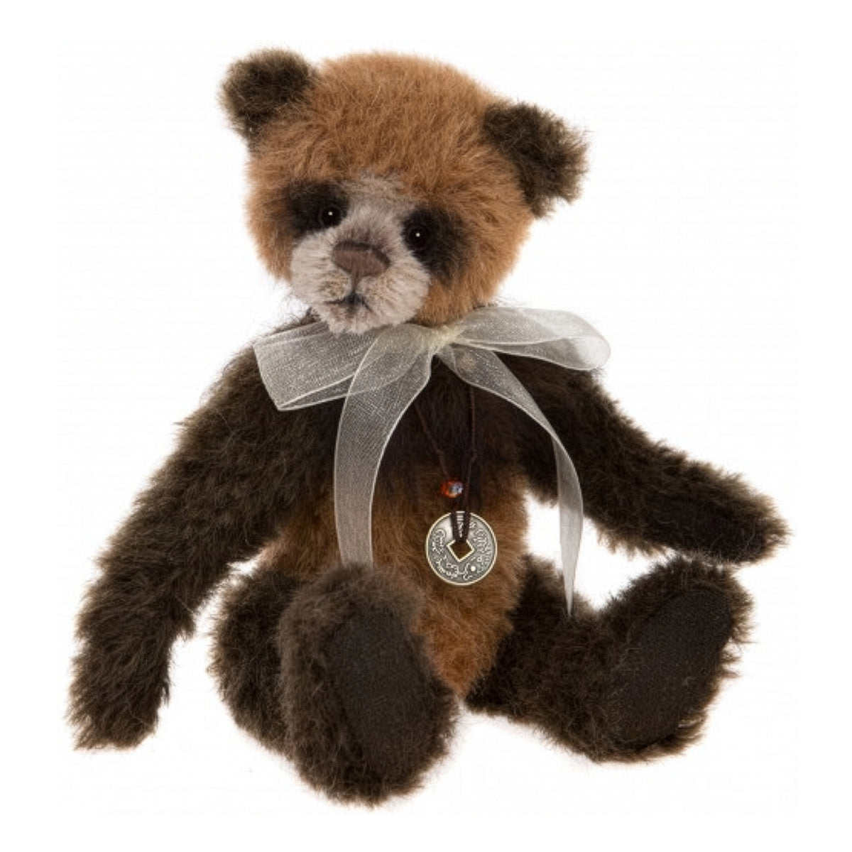 This is Guardian by Charlie Bears. This plush has long, slightly shaggy, matte fur with a soft sheen; the coat is primarily medium brown with much darker nearly black brown on the ears, limbs and around the eyes, and a white/cream short-pile muzzle and lower face. The muzzle is short-pile and visibly lighter than the rest of the head. The eyes are large, glossy black glass or plastic set into darker eye patches. The nose is stitched brown and the mouth is hand-stitched in dark thread. Paw pads appear d...